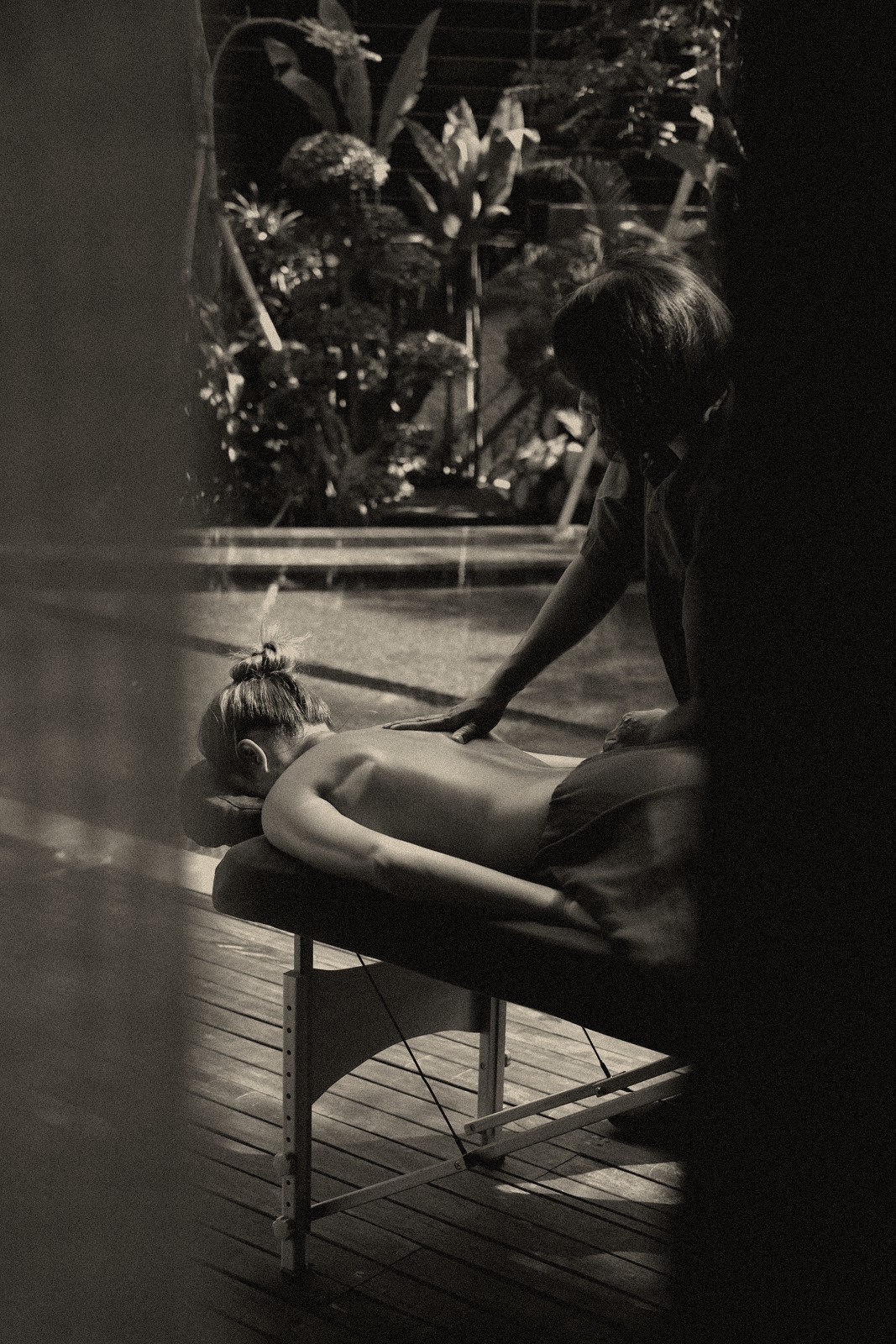A therapist giving a massage poolside